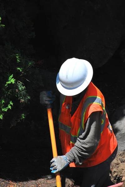 外の壊れた地下水管を修理する男 — ストック写真