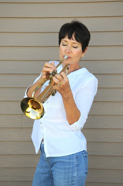 Mature female trumpet player. — Stock Photo, Image