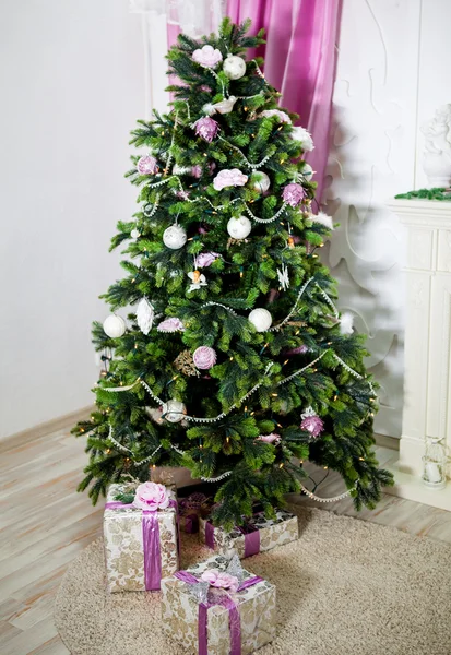 Weihnachtsbaum geschmückt mit weihnachtlichem Spielzeug und Geschenken im Foyer — Stockfoto