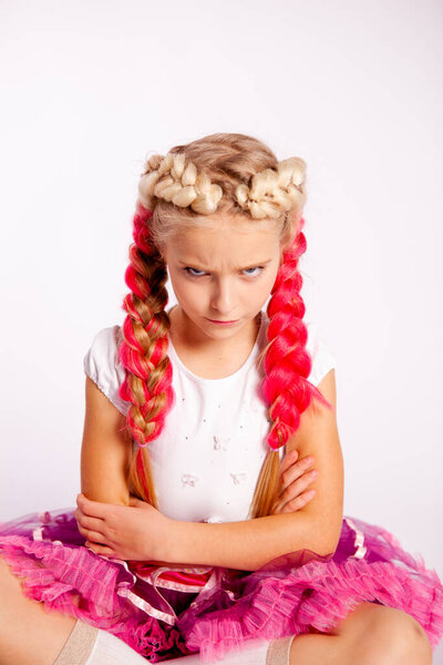 милая девушка с яркими косичками в белой одежде на белом фоне