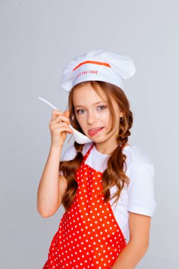 Aşçı şapkalı kız ve yemek pişirmek için önlük.