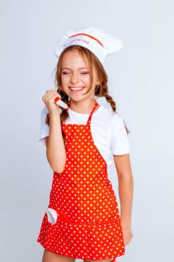 Aşçı şapkalı kız ve yemek pişirmek için önlük.