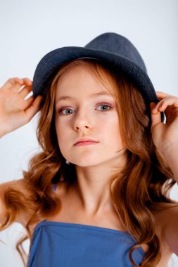 açık mavi bir elbise içinde spagetti kayışları üzerinde küçük bir kız beyaz arka planda