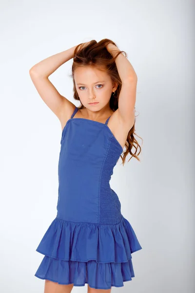 dressed in a light blue dress on spaghetti straps little girl on a white background