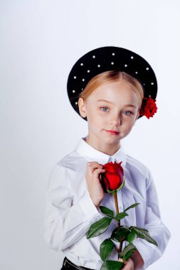 Siyah bereli ve resmi kıyafetli beş yaşında bir kız.