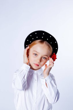 Siyah bereli ve resmi kıyafetli beş yaşında bir kız.