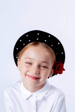 Siyah bereli ve resmi kıyafetli beş yaşında bir kız.