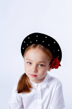 Siyah bereli ve resmi kıyafetli beş yaşında bir kız.