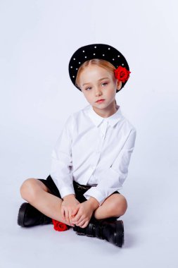 Siyah bereli ve resmi kıyafetli beş yaşında bir kız.