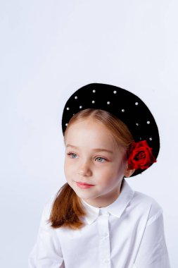 Siyah bereli ve resmi kıyafetli beş yaşında bir kız.