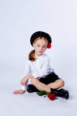 Siyah bereli ve resmi kıyafetli beş yaşında bir kız.