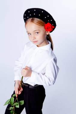 Siyah bereli ve resmi kıyafetli beş yaşında bir kız.