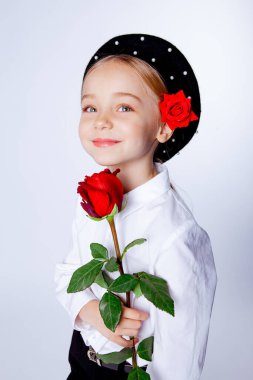 Siyah bereli ve resmi kıyafetli beş yaşında bir kız.