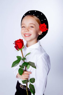 Siyah bereli ve resmi kıyafetli beş yaşında bir kız.