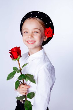 Siyah bereli ve resmi kıyafetli beş yaşında bir kız.