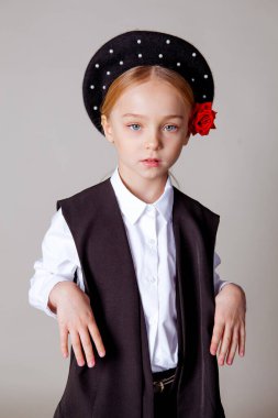 Siyah bereli ve resmi kıyafetli beş yaşında bir kız.