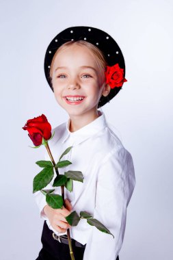 Siyah bereli ve resmi kıyafetli beş yaşında bir kız.