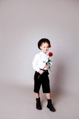 Siyah bereli ve resmi kıyafetli beş yaşında bir kız.