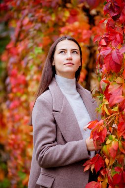 Yeşilliğin arka planında uzun saçlı esmer