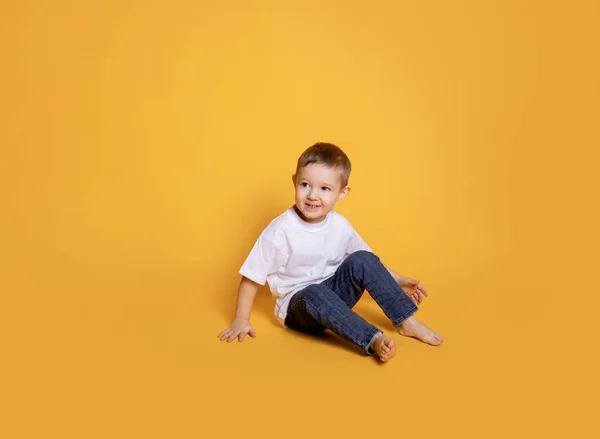 Niño Pequeño Jeans Una Camiseta Blanca Sobre Fondo Amarillo — Foto de Stock