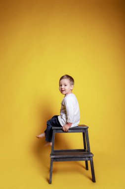 Kotlu küçük bir çocuk ve beyaz bir kazak.