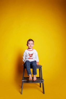 Kotlu küçük bir çocuk ve beyaz bir kazak.