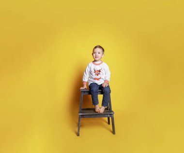 Kotlu küçük bir çocuk ve beyaz bir kazak.