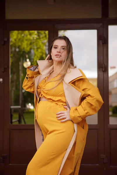 Zwangere Vrouw Geel Pak Gele Regenjas Achtergrond Van Deur — Stockfoto