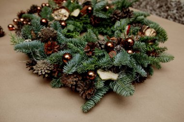 Noel çelengi fındık kabuğu, kozalak ve boncuklarla süslenmiş.