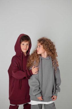 Uzun saçlı kız ve eşofmanlı çocuk.