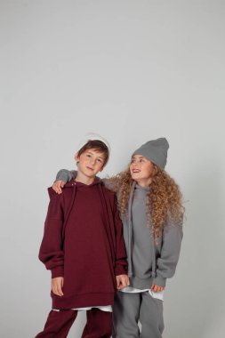 Uzun saçlı kız ve eşofmanlı çocuk.