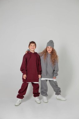 Uzun saçlı kız ve eşofmanlı çocuk.