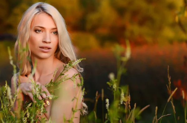 Blond tjej utomhus på flodbanken vid solnedgången. — Stockfoto