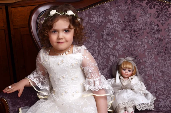 Little girl in dress sitting on chair — Stock Photo, Image