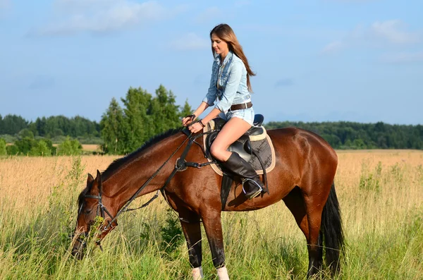 Vrouw op paard in het veld — Stockfoto