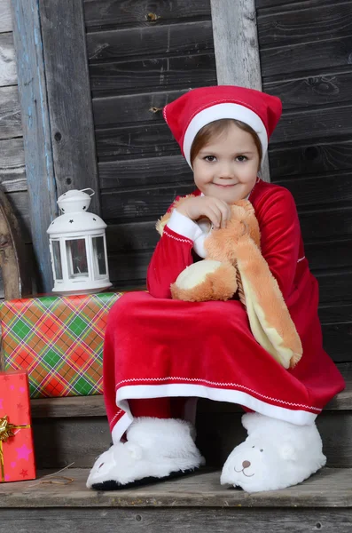 Meisje in Kerstman hoed met Kerst presenteert — Stockfoto