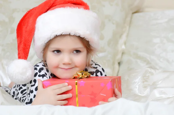 Klein meisje in Kerstman hoed Stockfoto