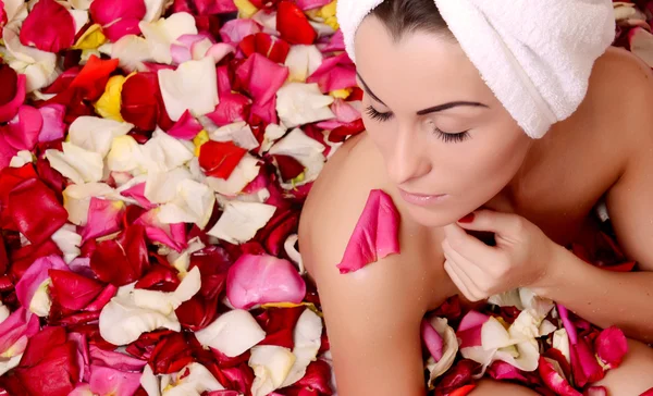 Mujer en baño con pétalos de rosas — Foto de Stock