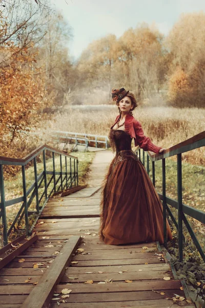 Hermosa Mujer Vestido Histórico Baja Por Una Escalera Madera Para Imagen de archivo