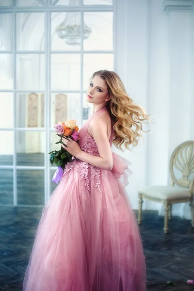 一个漂亮的金发姑娘的画像 她的头发飘逸 穿着粉红色的老式礼服 开着一束花 — 图库照片