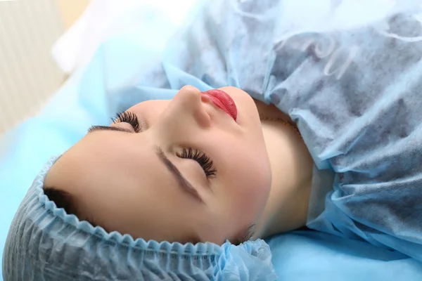 Kosmetikerin schminkt das Gesicht einer Frau dauerhaft — Stockfoto