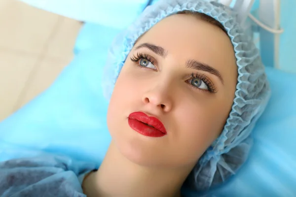 Cosmetologist making permanent makeup on woman's face — Stock Photo, Image