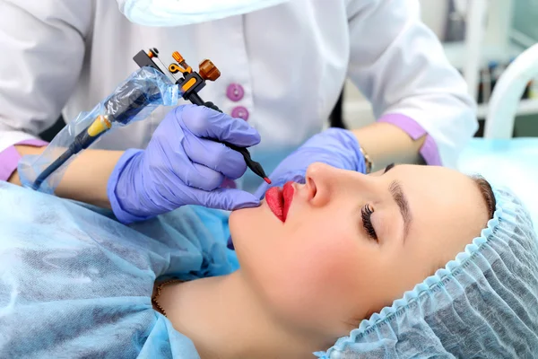 Kosmetolog göra permanent makeup på kvinnans ansikte — Stockfoto