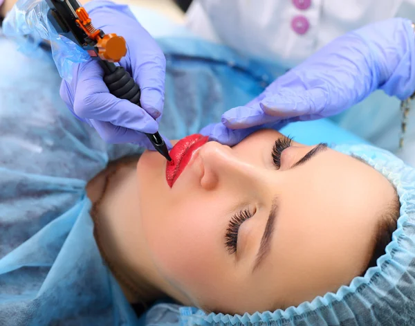 Cosmetologist making permanent makeup on woman's face — Stock Photo, Image