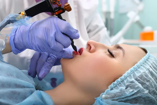 Cosmetologist making permanent makeup on woman's face — Stock Photo, Image