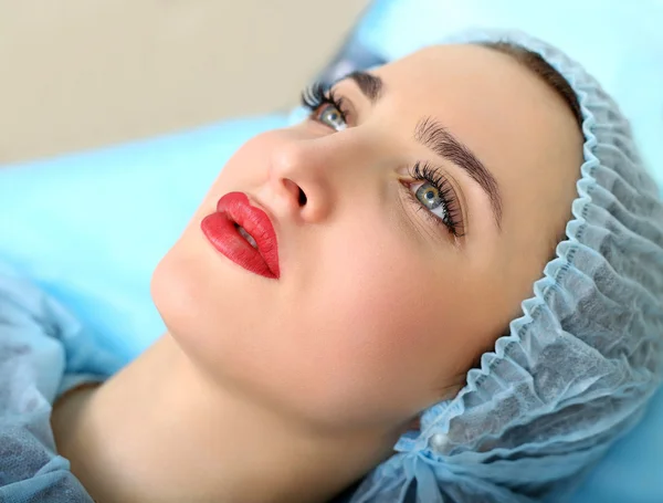 Cosmetologist making permanent makeup on woman's face — Stock Photo, Image