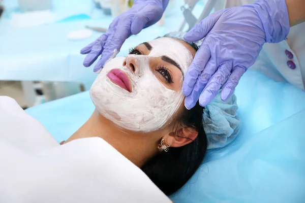Доктор косметолог наносит глиняную маску на руки красивым во — стоковое фото