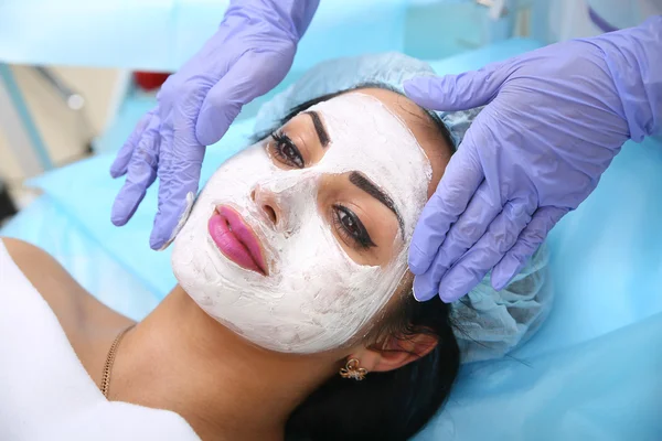 Médico esteticista aplica uma máscara de barro em mãos de cara bela wo — Fotografia de Stock