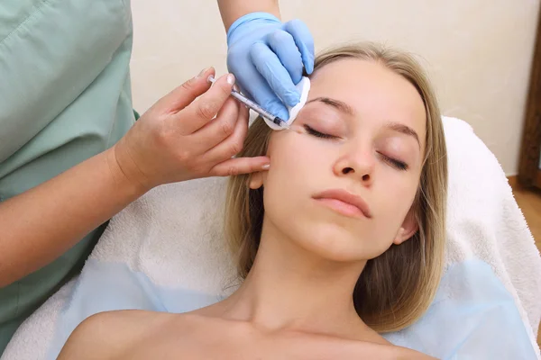 Hermosa mujer recibe una inyección en su cara . —  Fotos de Stock