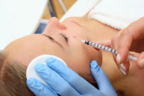 Beautiful woman gets an injection in her face.